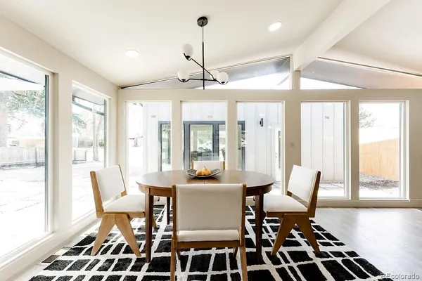 a dining room with furniture a chandelier and window