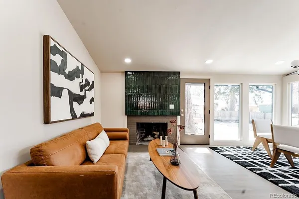 a living room with furniture a fireplace and a floor to ceiling window