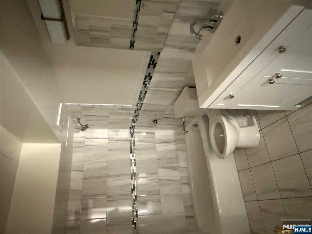 873 Main Street, Unit 2E Hackensack, NJ 07601 - Photo 11 of 14 a bathroom with a sink a toilet and a bathtub