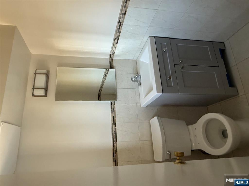 873 Main Street, Unit 2E Hackensack, NJ 07601 - Photo 13 of 14 a bathroom with a sink toilet and mirror