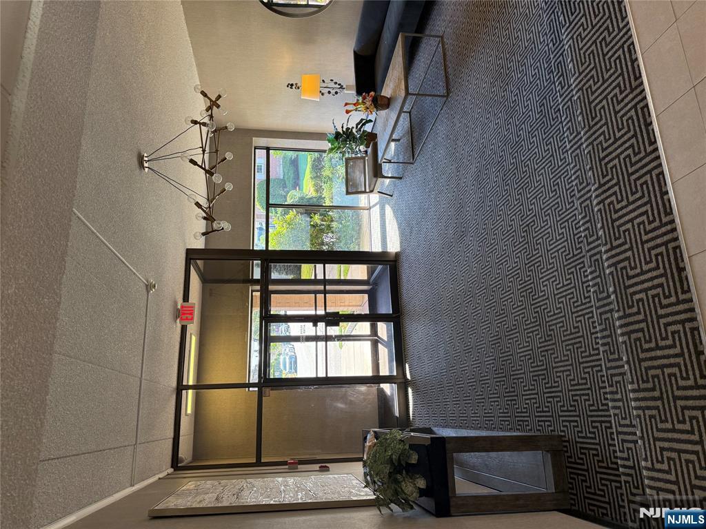 873 Main Street, Unit 2E Hackensack, NJ 07601 - Photo 2 of 14 a living room with furniture a window and a chandelier