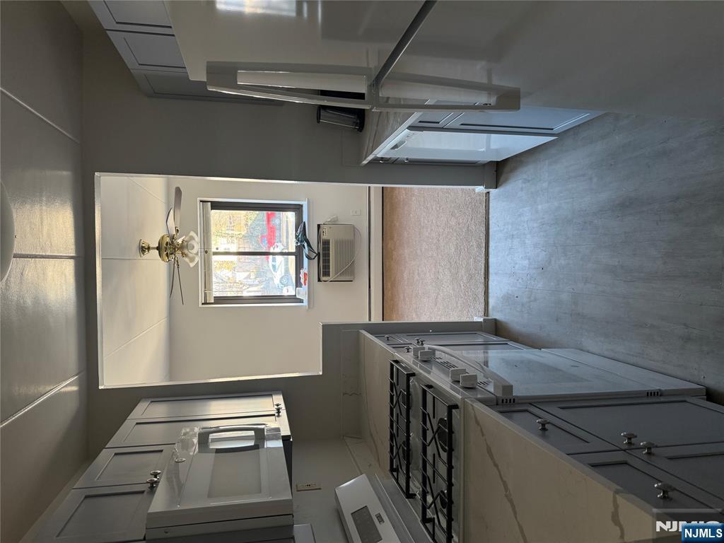 873 Main Street, Unit 2E Hackensack, NJ 07601 - Photo 4 of 14 a kitchen with granite countertop a sink stove and refrigerator