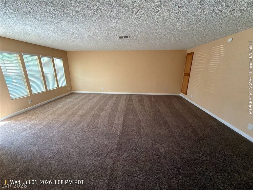 2313 Ragland Street Las Vegas, NV 89108 - Photo 3 of 11 A spacious room with fresh carpeting and ample natural light through multiple windows.