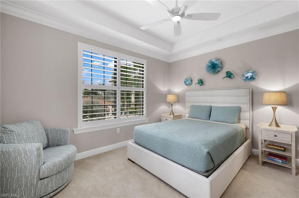 16449 Carrara Way, Unit 101 Naples, FL 34110 - Photo 18 of 35 Guest Bedroom 1 featuring crown molding, a tray ceiling, and plantation shutters.