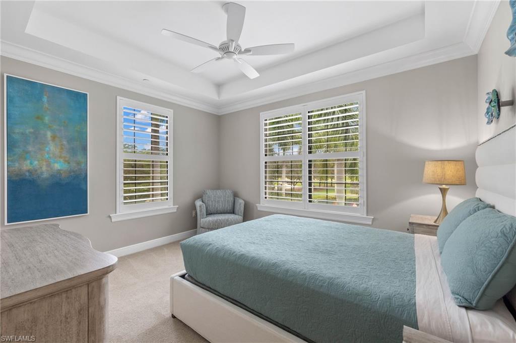 16449 Carrara Way, Unit 101 Naples, FL 34110 - Photo 19 of 35 Guest Bedroom 1 with a tray ceiling, and a ceiling fan.