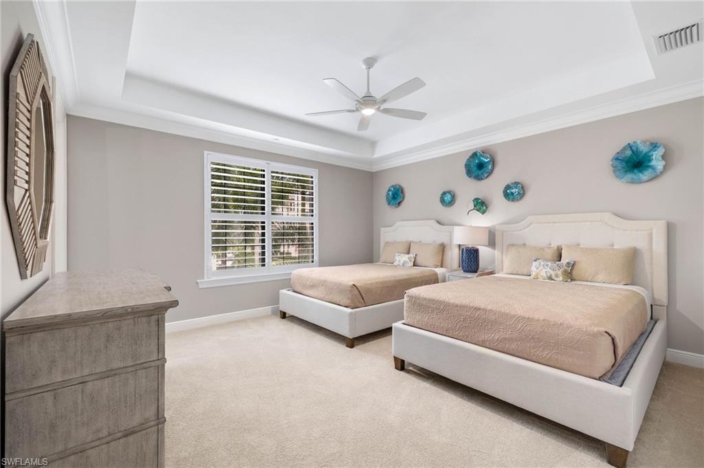16449 Carrara Way, Unit 101 Naples, FL 34110 - Photo 21 of 35 Guest Bedroom 2 featuring a tray ceiling, a ceiling fan, and plantation shutters.