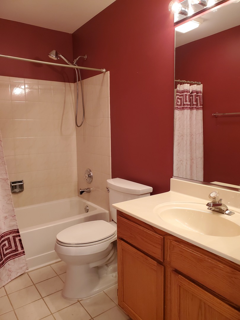 8225 Ripple Ridge, Unit 8225 Darien, IL 60561 - Photo 16 of 21 a bathroom with a sink a toilet and shower