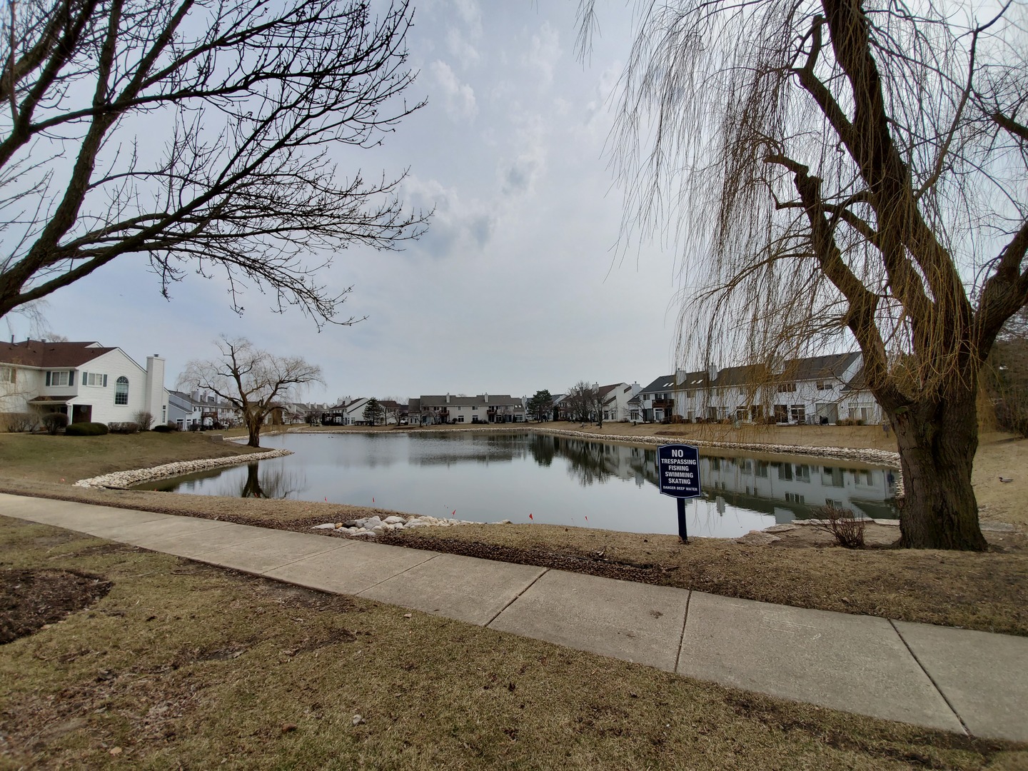8225 Ripple Ridge, Unit 8225 Darien, IL 60561 - Photo 21 of 21 a view of a lake with a bench and large trees