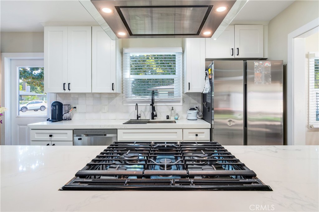 6755 Rainier Court Riverside, CA 92506 - Photo 5 of 23 a kitchen with stainless steel appliances granite countertop a stove a refrigerator a sink dishwasher and white cabinets next to a window