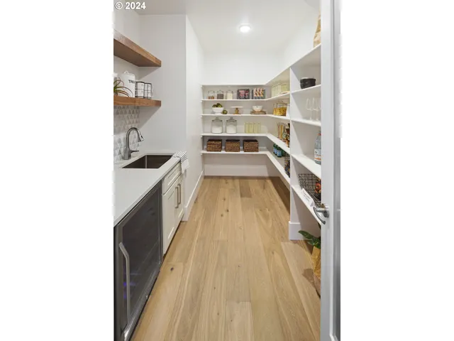 a hallway with a white cabinets and wooden floor