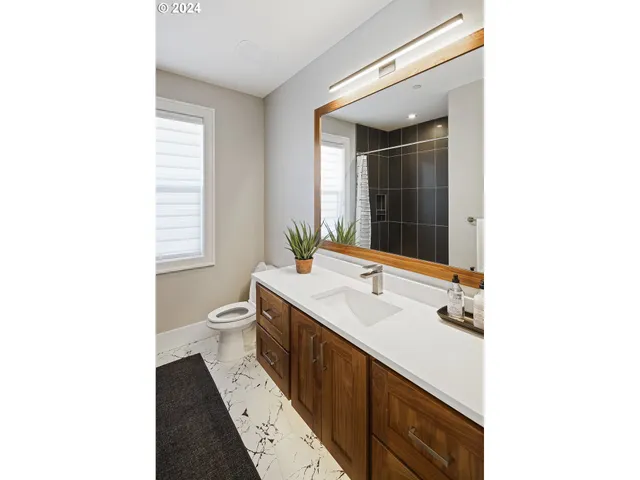 a bathroom with a double vanity sink toilet and mirror