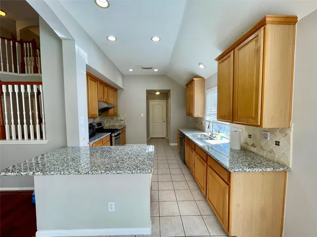 a kitchen with stainless steel appliances granite countertop a sink stove and cabinets