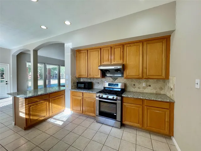 a kitchen with stainless steel appliances granite countertop a sink and a stove