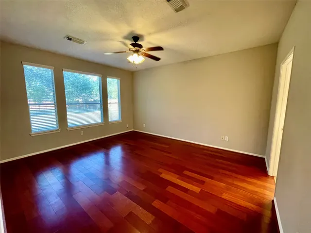 a view of an empty room with wooden floor