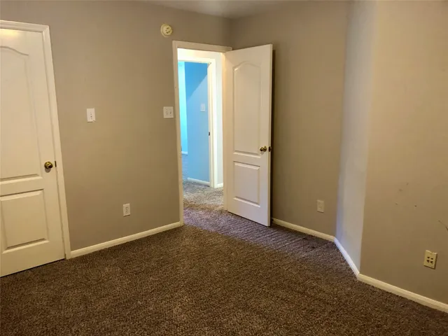 an empty room with closet and a ceiling fan