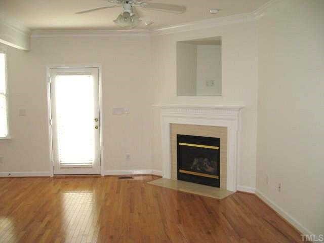 5406 Goldenglow Way Raleigh, NC 27606 - Photo 3 of 12 an empty room with wooden floor fireplace and window
