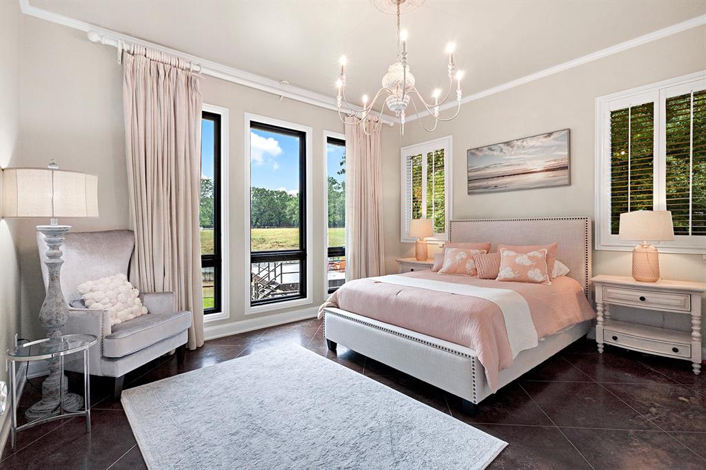 103 Glenn Road Mabank, TX 75156 - Photo 22 of 38 a bedroom with a large bed and a chandelier