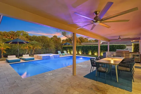 a view of a swimming pool with a table and chairs under an umbrella