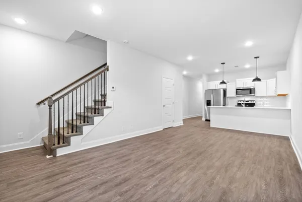 a view of a kitchen with wooden floor and electronic appliances