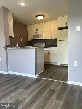 a kitchen with granite countertop a stove and a refrigerator