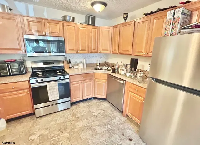 a kitchen with stainless steel appliances a stove a sink and a refrigerator