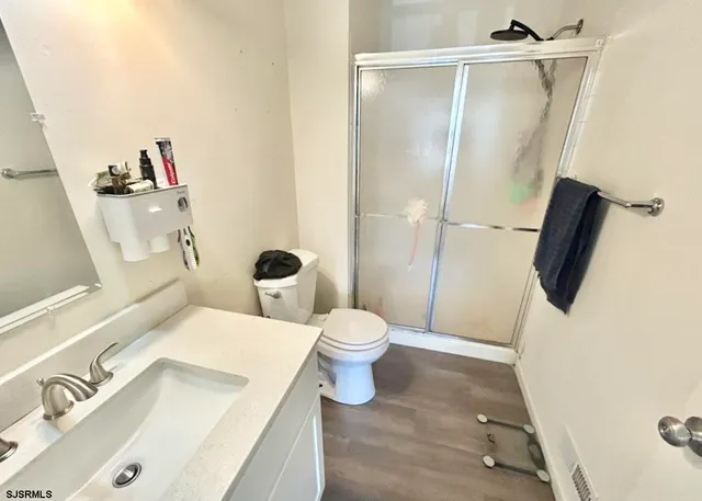a bathroom with a sink a toilet and shower