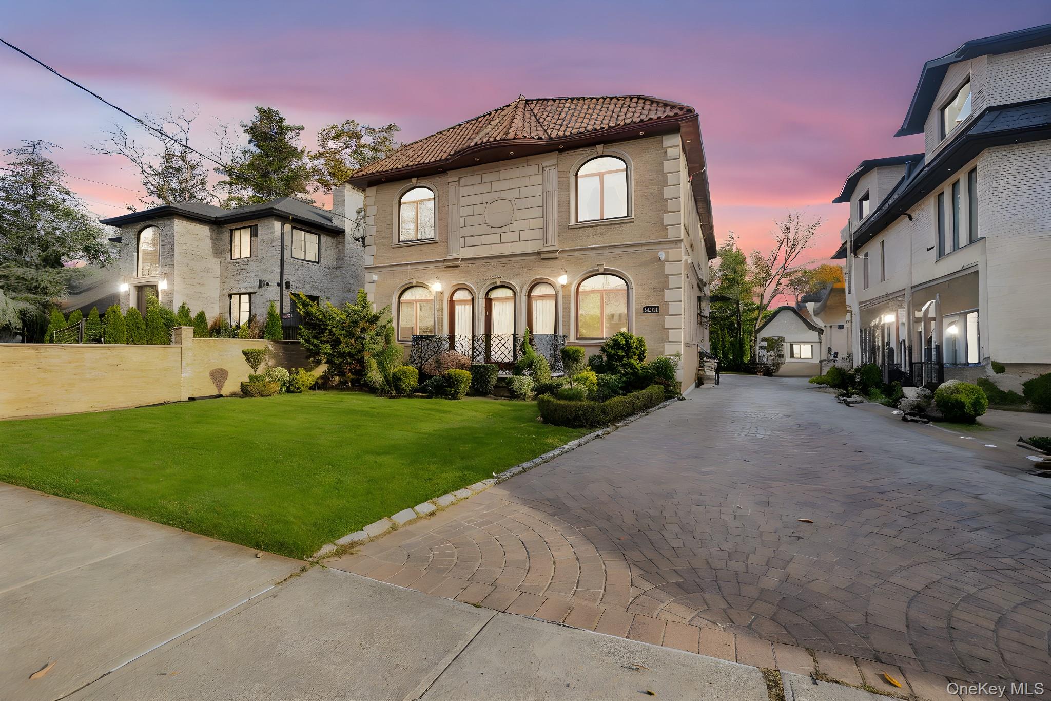 a front view of a house with a yard and potted plants