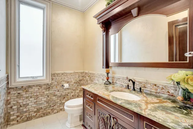 a bathroom with a granite countertop sink toilet and mirror