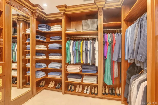 a view of walk in closet with clothes and shoes