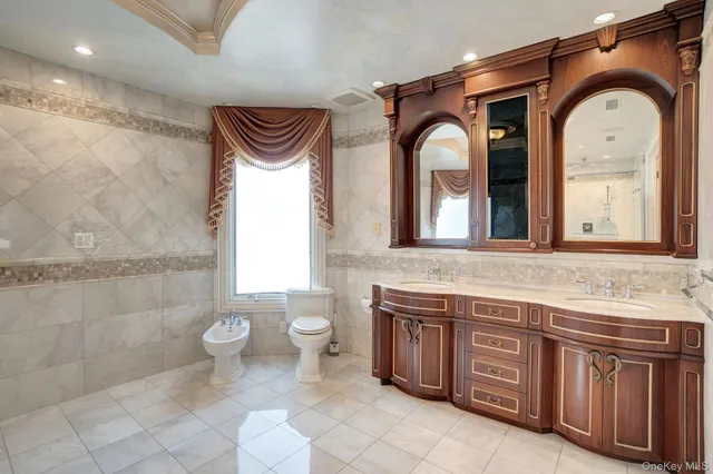 a bathroom with a granite countertop toilet a sink and a mirror