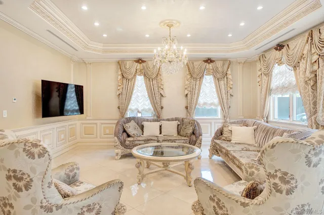 a living room with large couches and a dining table with kitchen view