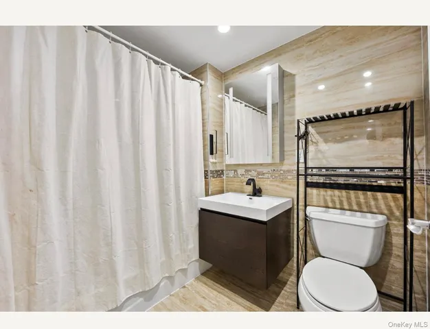 a bathroom with a toilet a sink and a mirror