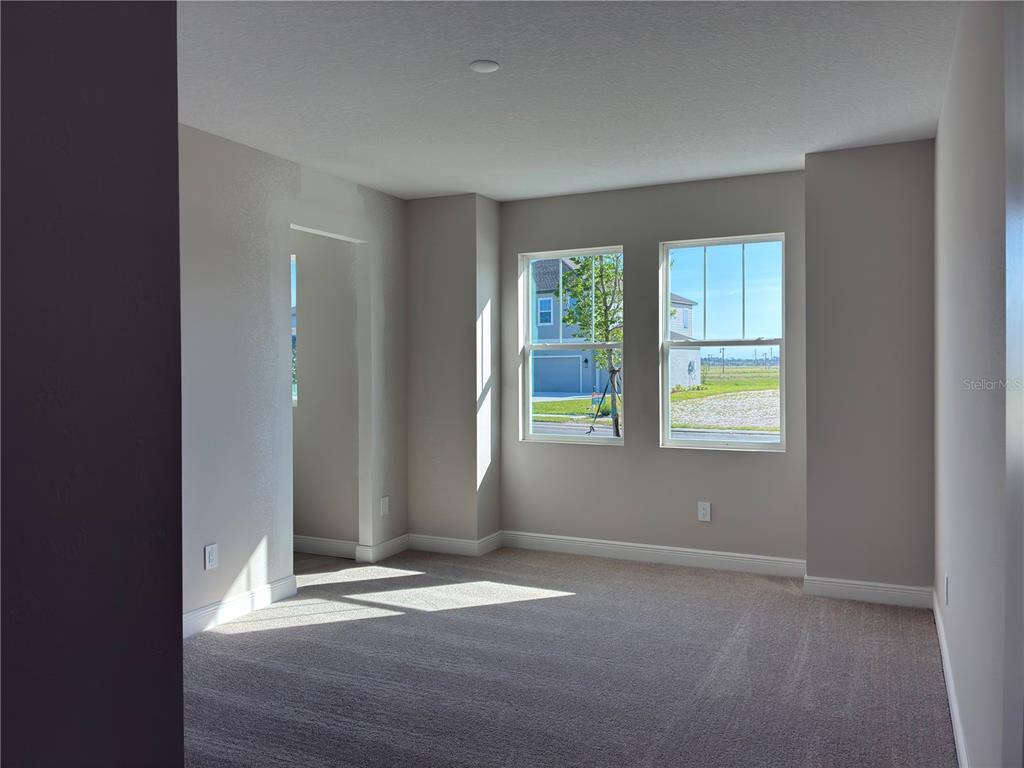 10037 Hidden Hammock Loop Parrish, FL 34221 - Photo 12 of 19 an empty room with wooden floor and windows