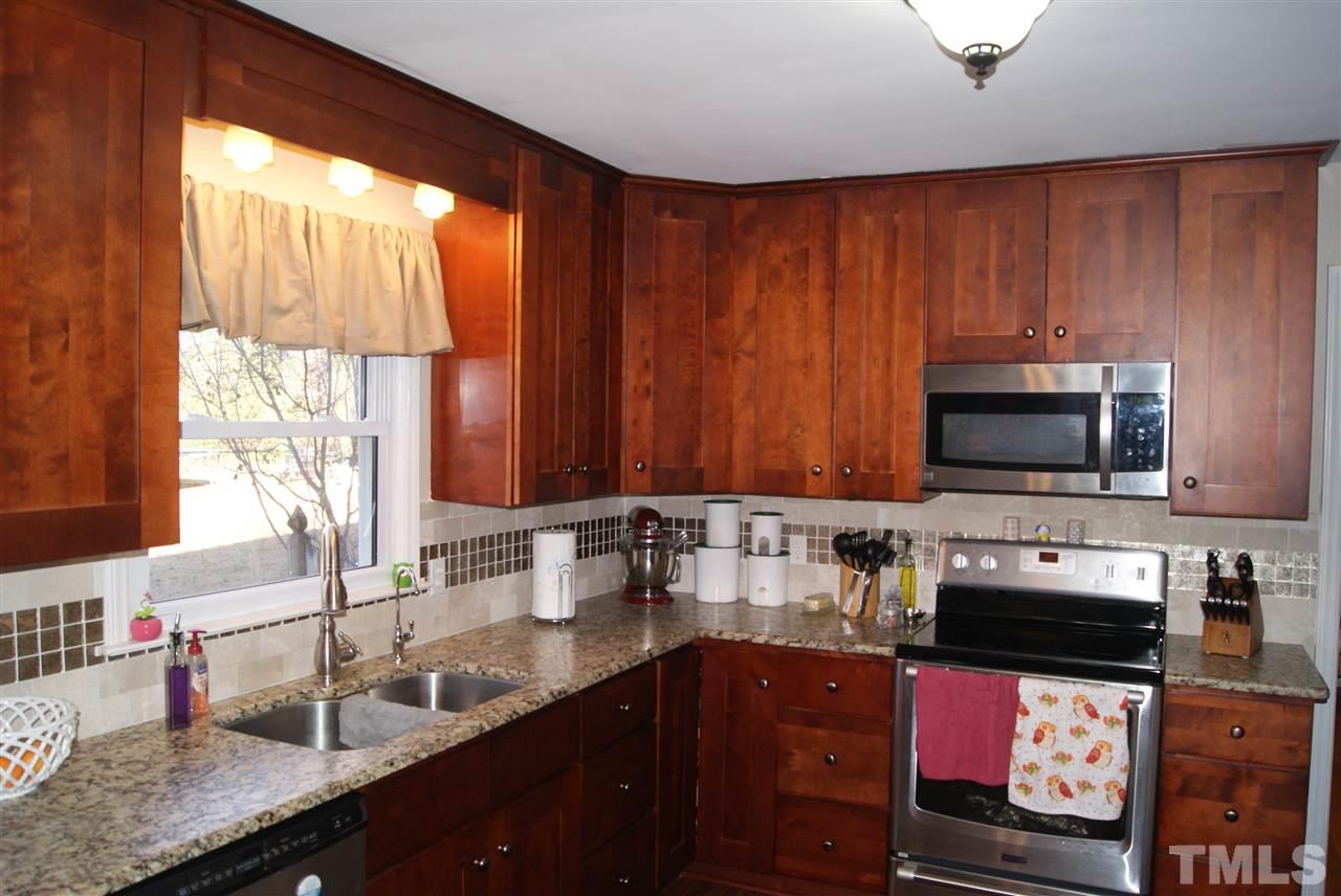 3209 Marie Drive Raleigh, NC 27604 - Photo 11 of 25 a kitchen with stainless steel appliances wooden cabinets a stove and a sink