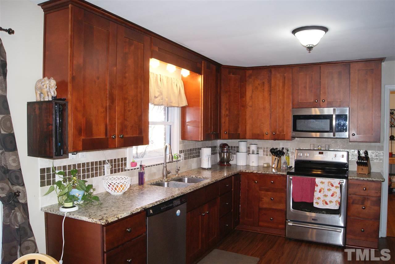 3209 Marie Drive Raleigh, NC 27604 - Photo 10 of 25 a kitchen with stainless steel appliances wooden cabinets a stove and a sink