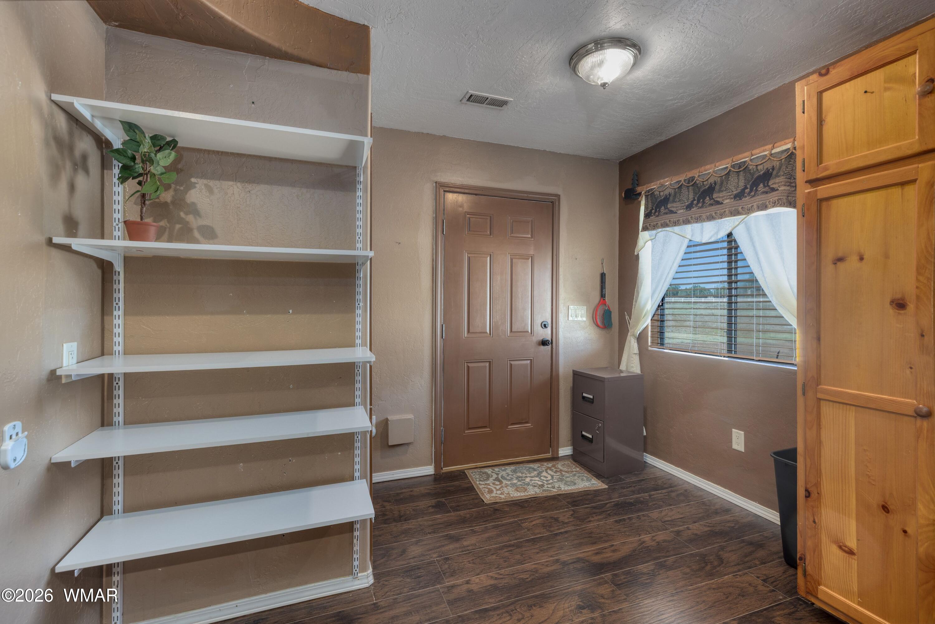 2722 Bain Trail Overgaard, AZ 85933 - Photo 6 of 28 a view of an empty room with wooden floor and a window