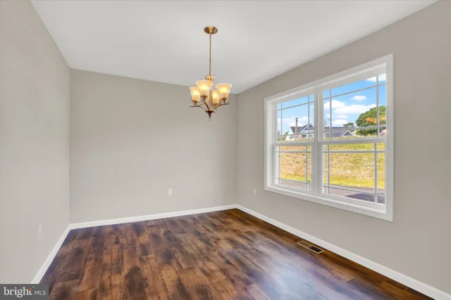 a view of a room with wooden floor and a chandelier