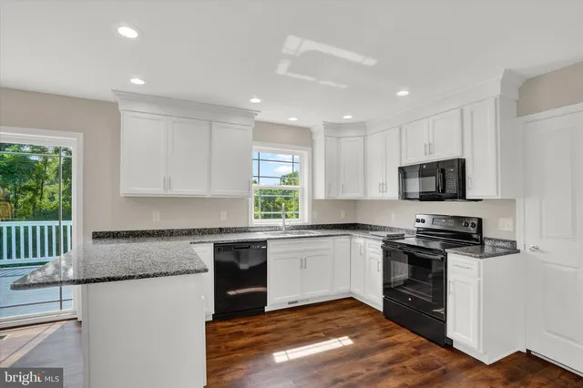 a kitchen with granite countertop white cabinets and white appliances