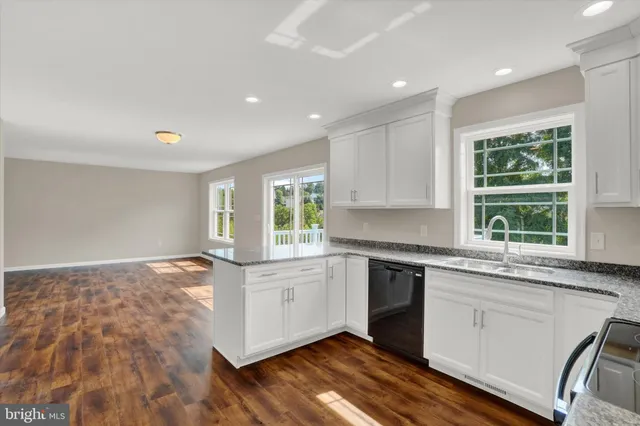 a view of a kitchen with wooden floor and a sink