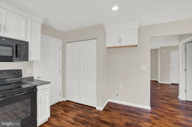 a view of a room with wooden floor chandelier and windows