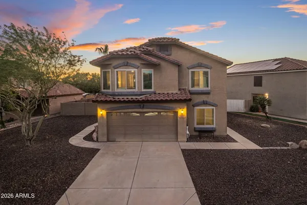 a front view of a house with yard and parking