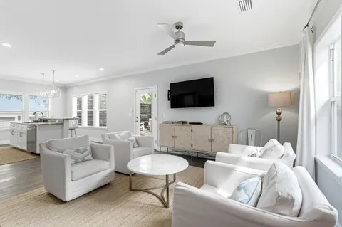 a kitchen with a refrigerator a sink dishwasher a stove and a dining table with wooden floor