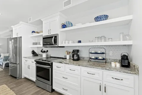 a kitchen with stainless steel appliances granite countertop a sink stove and cabinets