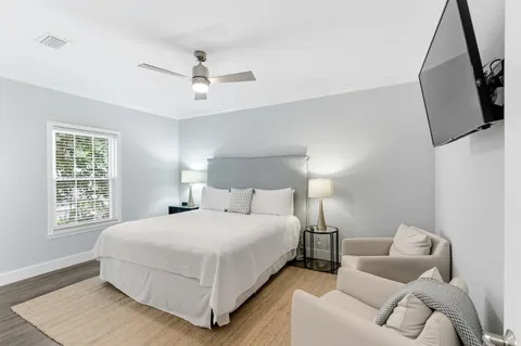 a bedroom with a bed a couch and a flat screen tv