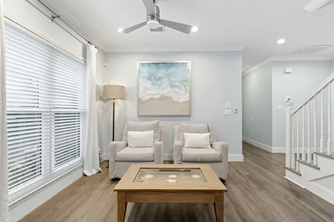 a living room with furniture a flat screen tv and a large window