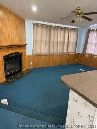 a view of an empty room with a fireplace and a window