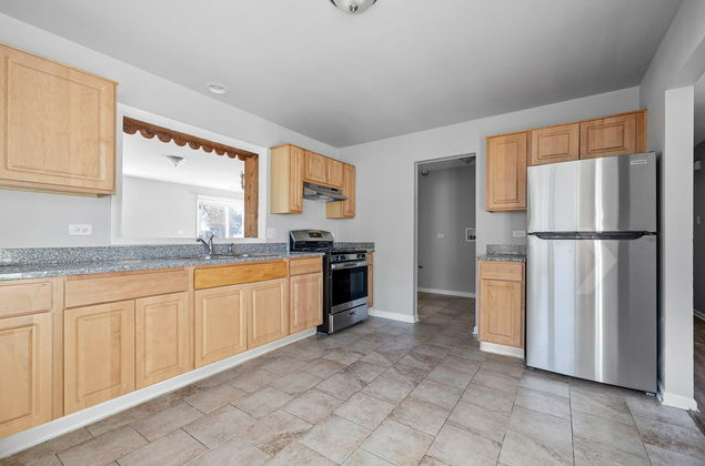 547 Regent Road University Park, IL 60484 - Photo 4 of 14 a kitchen with granite countertop a refrigerator and a sink