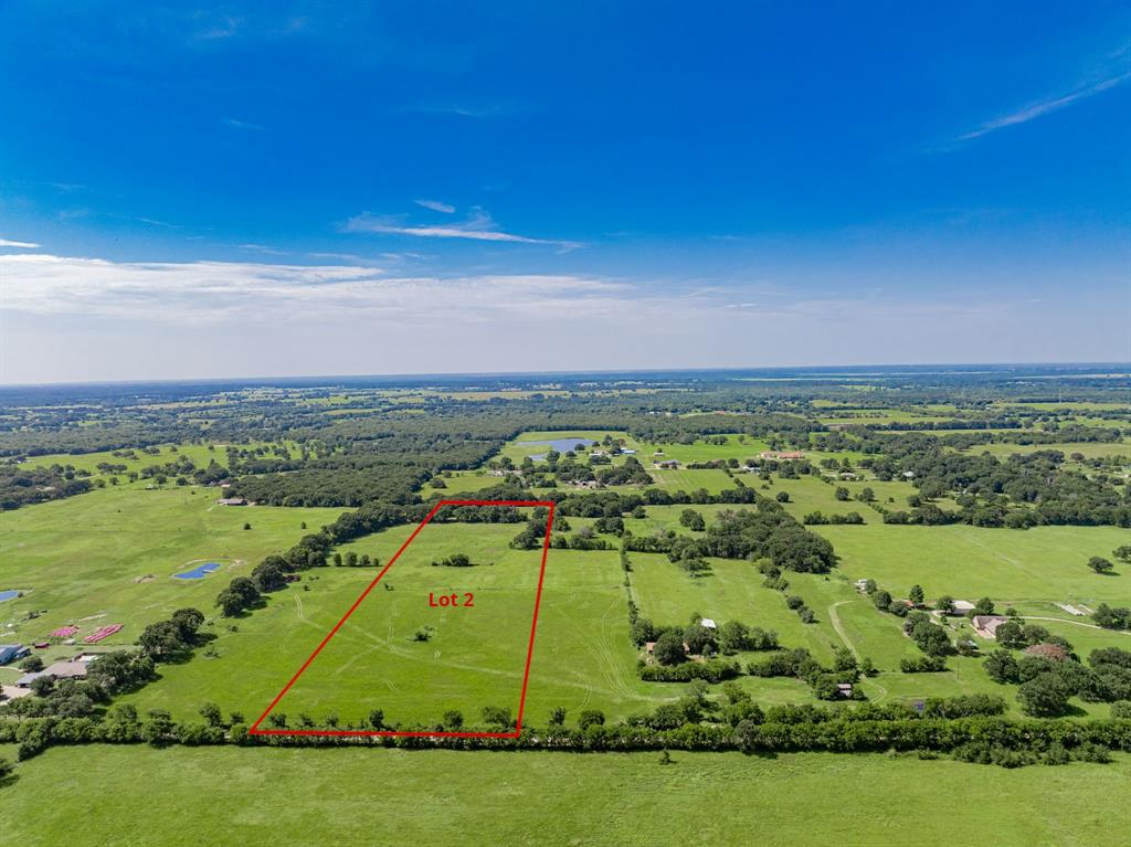 Expansive Lot 2 featuring a large grass field and a clear, open sky