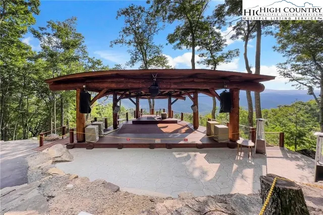 a backyard of a house with large trees and wooden fence