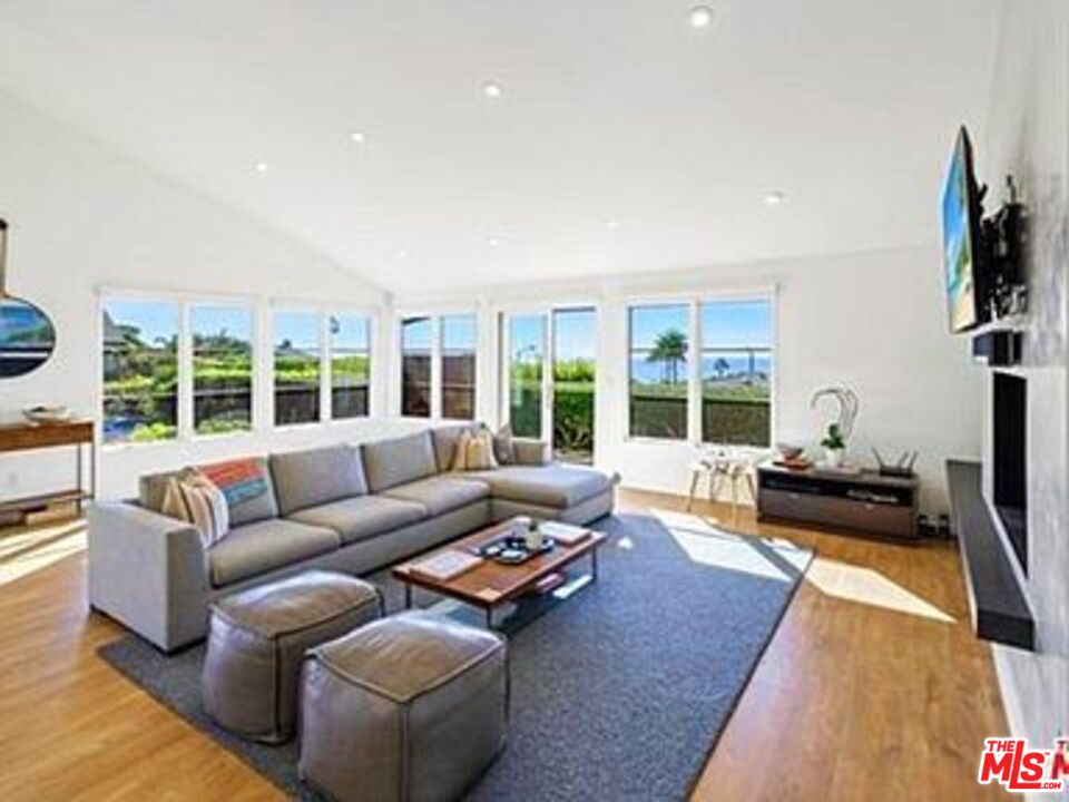 Roca Chica Drive Malibu, CA 90265 - Photo 3 of 34 a living room with furniture floor to ceiling window and a flat screen tv